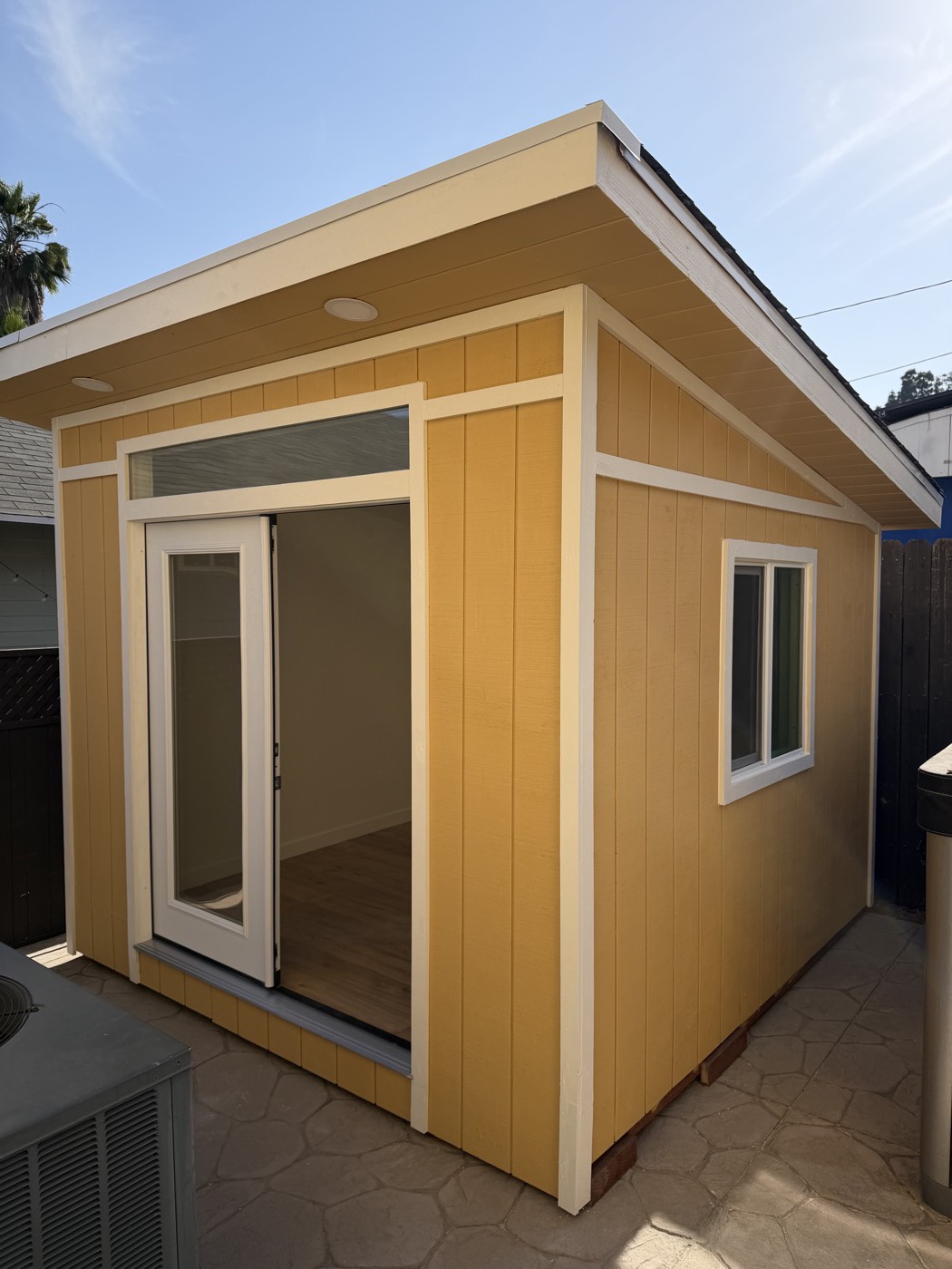 Yellow 10 by 10 ft gym studio seen from the side with the door open
