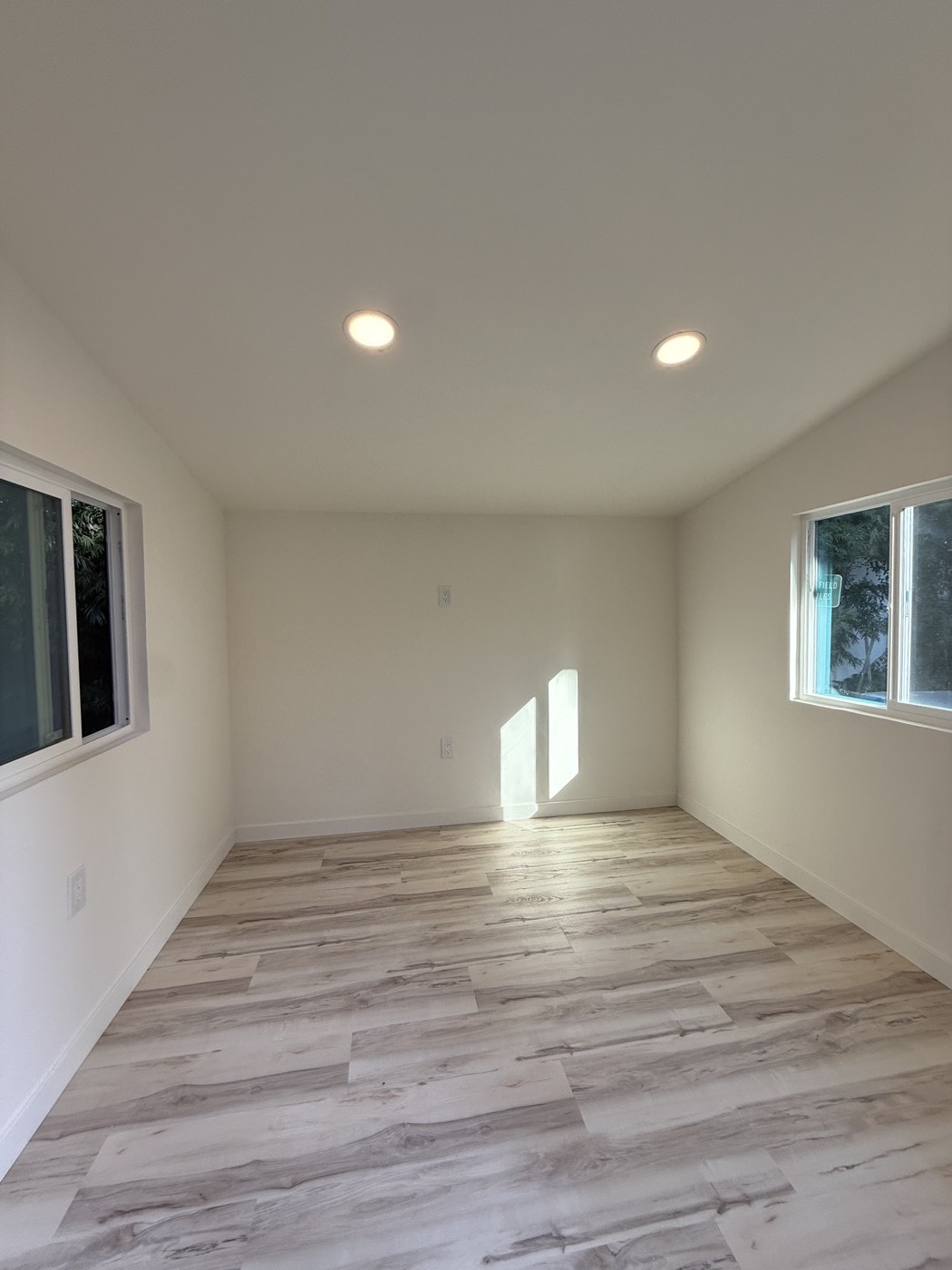 Side view of the white 10 by 10 ft backyard office with black window trim