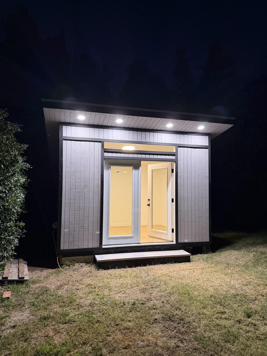 Grey 10 by 12 ft home office lit from within at night in Northridge